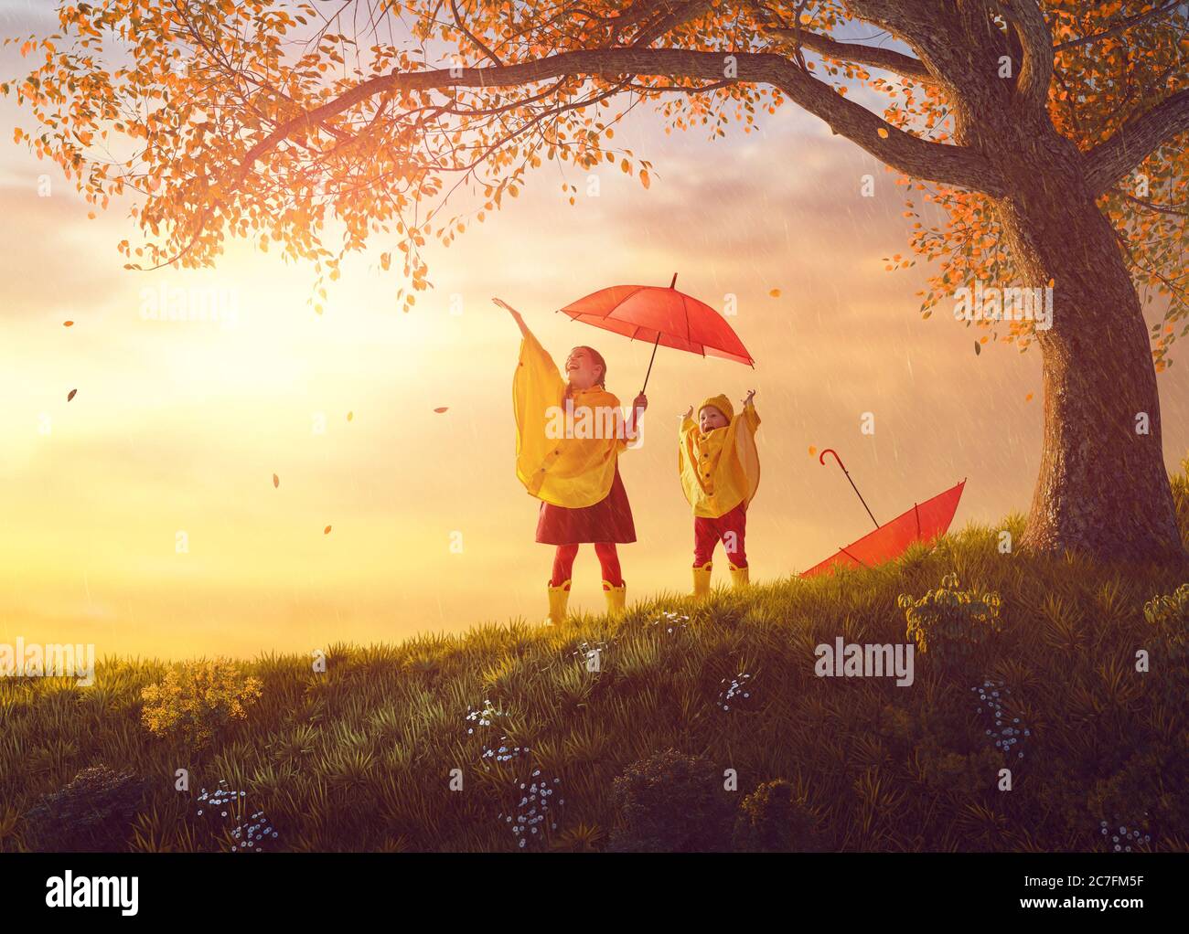 Deux enfants heureux drôle sous la douche d'automne. Les filles portent des imperméables jaunes et profitent de la pluie. Sœurs jouant ensemble sur la nature dehors Banque D'Images