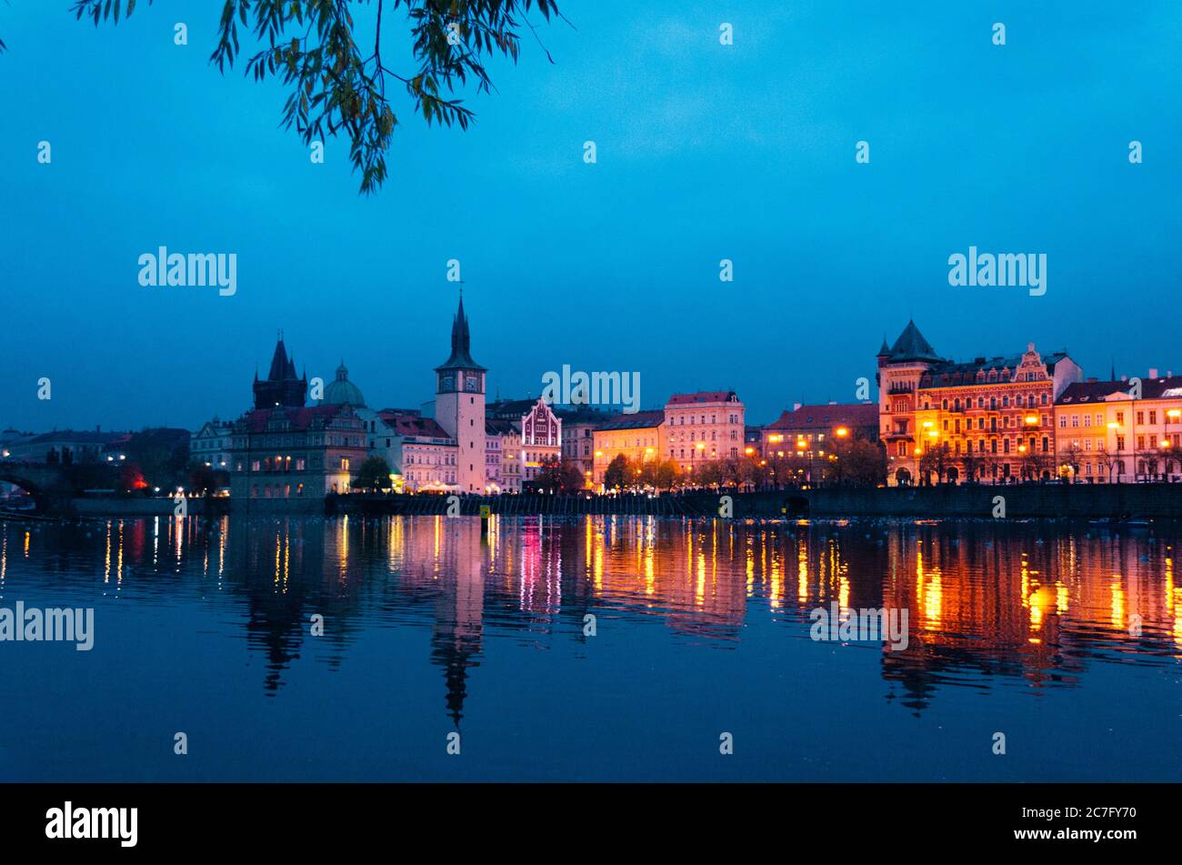 Une soirée tôt à Prague en automne avec des lumières incandescentes illuminant la ville et des réflexions sur la Vltava avec plusieurs canards flottent Banque D'Images