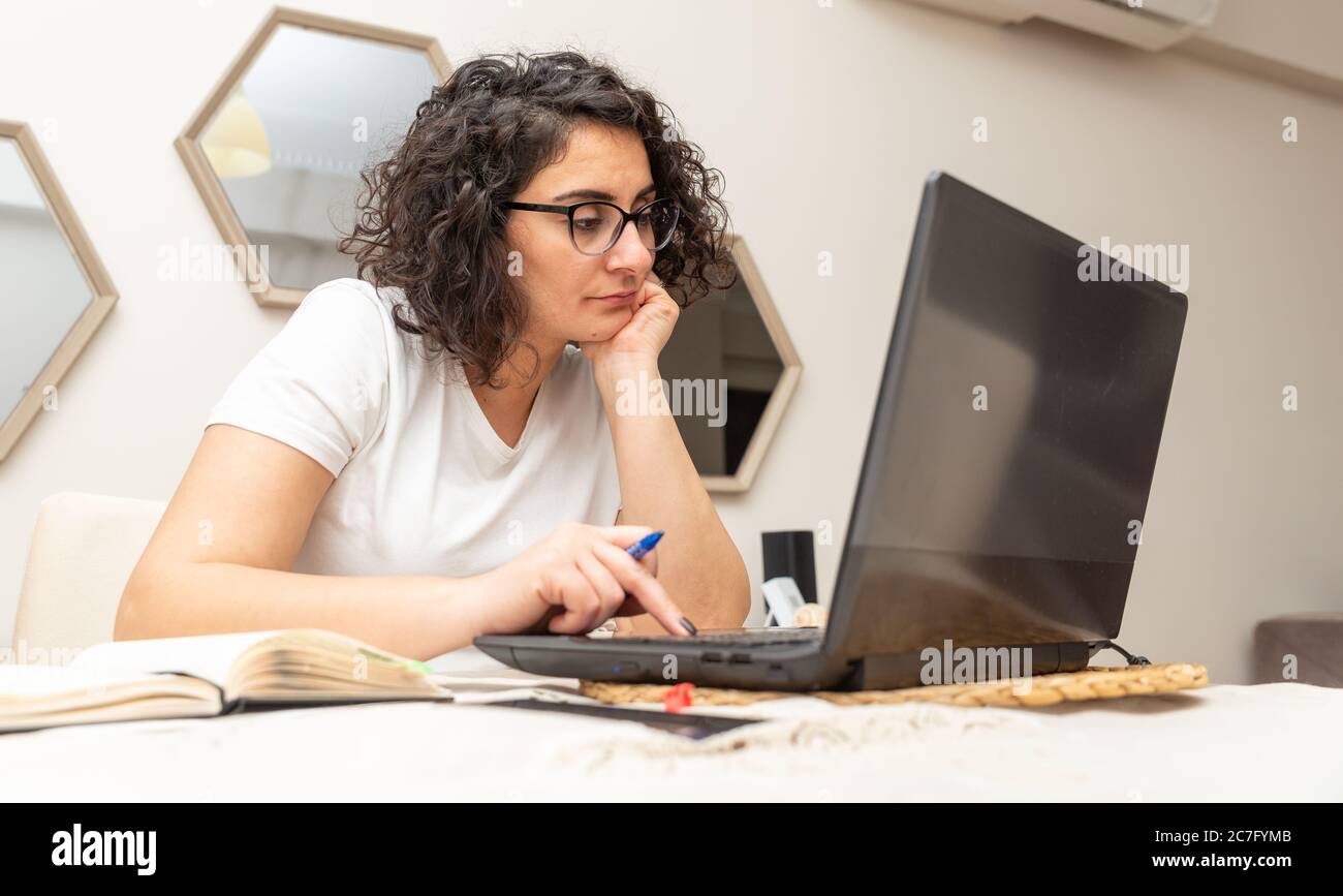 Jeune femme belle s'ennuiait avec beaucoup de travail et de travail sur ordinateur portable à la maison bureau lumineux. Banque D'Images