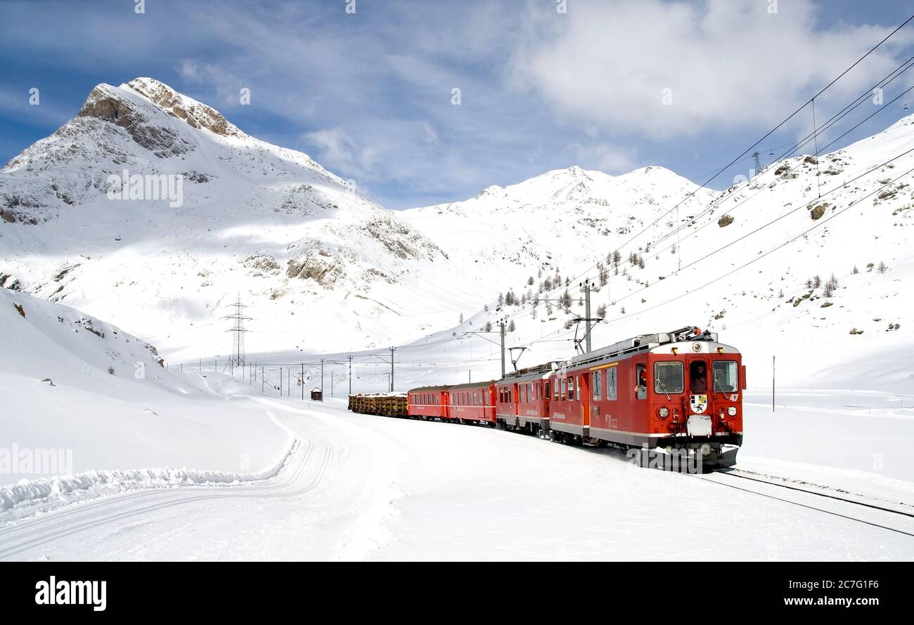 Bernina Express (train rouge), site classé au patrimoine mondial de l'UNESCO, à travers la neige Banque D'Images
