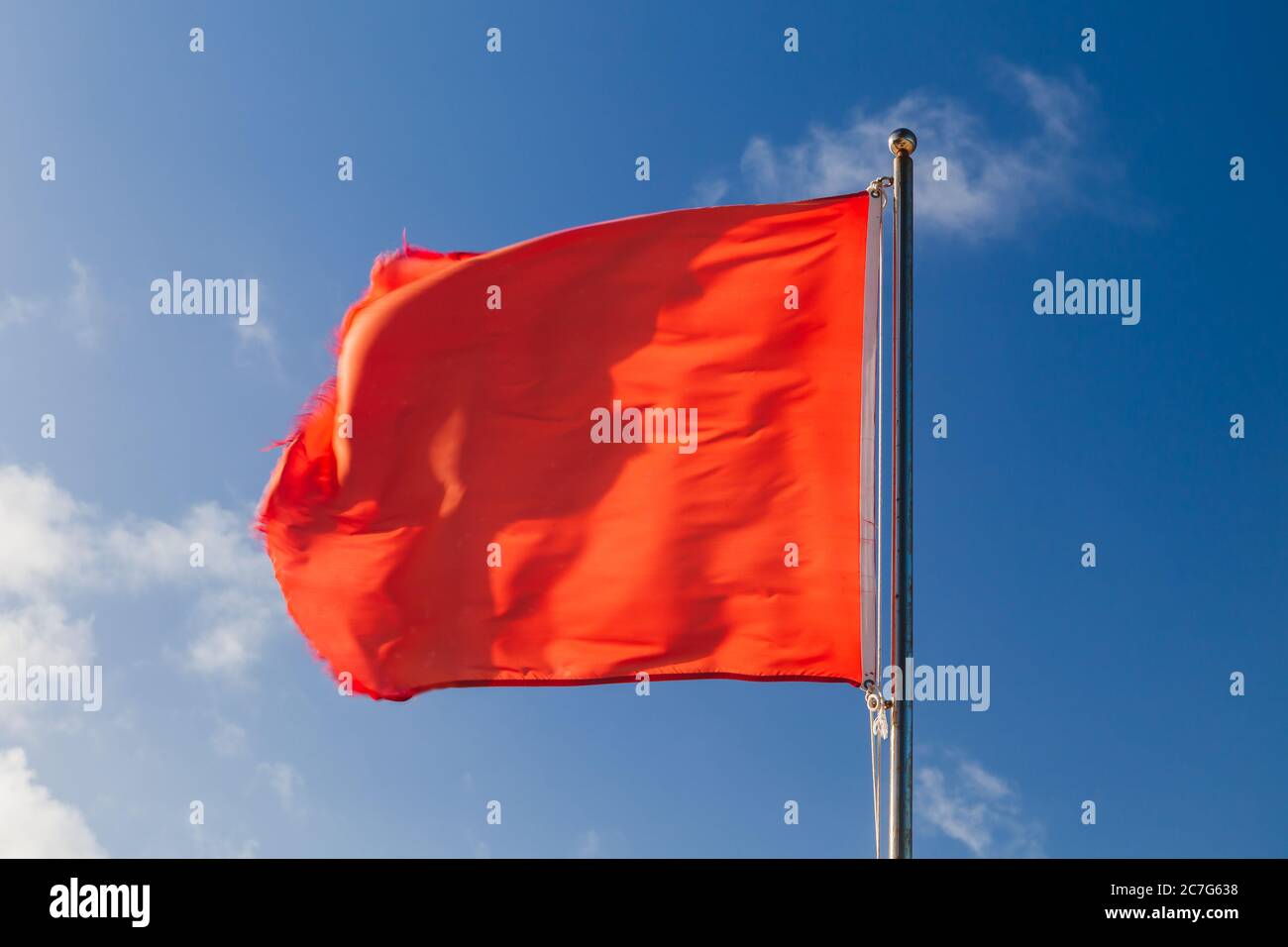 La natation est interdite. Drapeau rouge sur une station de sauveteurs de plage agitant sur un vent fort au-dessus du ciel bleu Banque D'Images