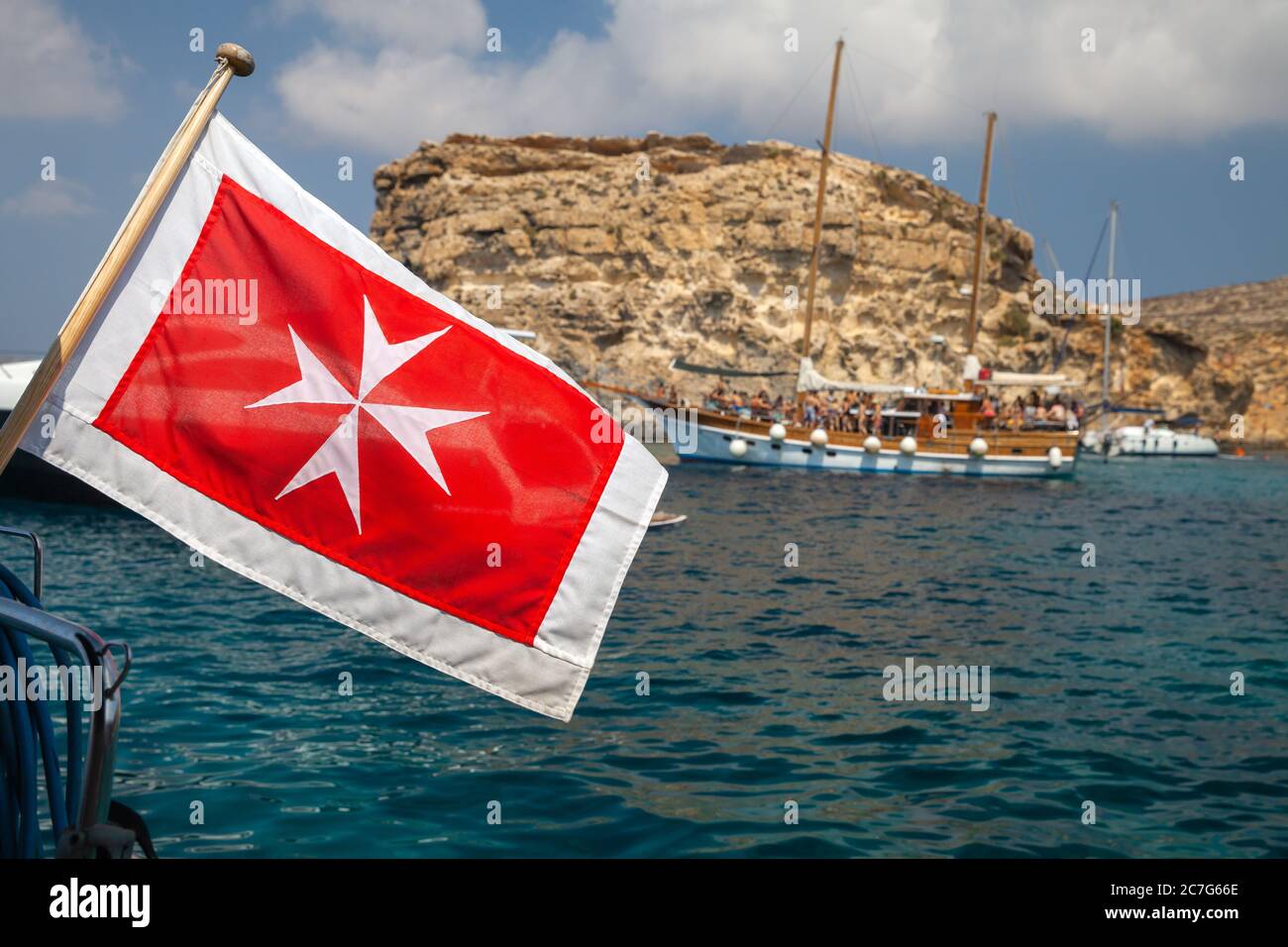 Le drapeau marchand de Malte monté sur le yacht poupe agitant sur le vent, la photo de gros plan avec une mise au point sélective et le bateau à voile flou sur un fond Banque D'Images