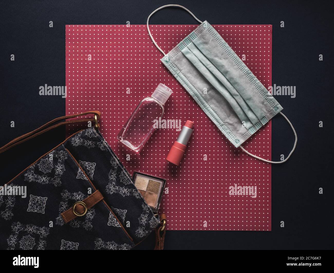 Sac pour femme avec rouge à lèvres, ombre à paupières, gel désinfectant pour les mains et masque facial. Banque D'Images