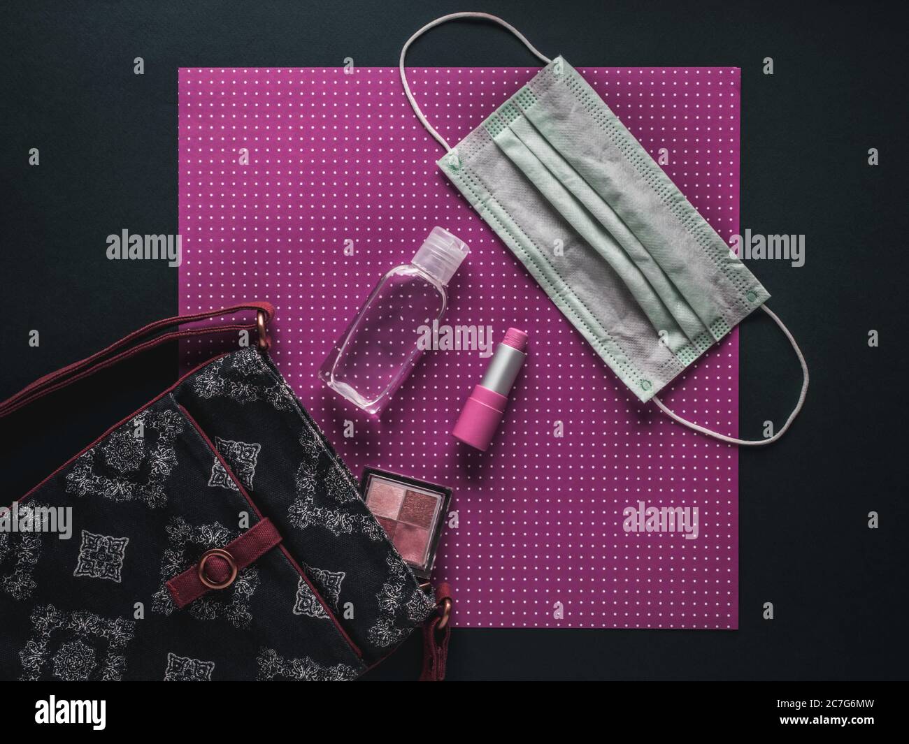 Sac pour femme avec rouge à lèvres, ombre à paupières, gel désinfectant pour les mains et masque facial. Banque D'Images