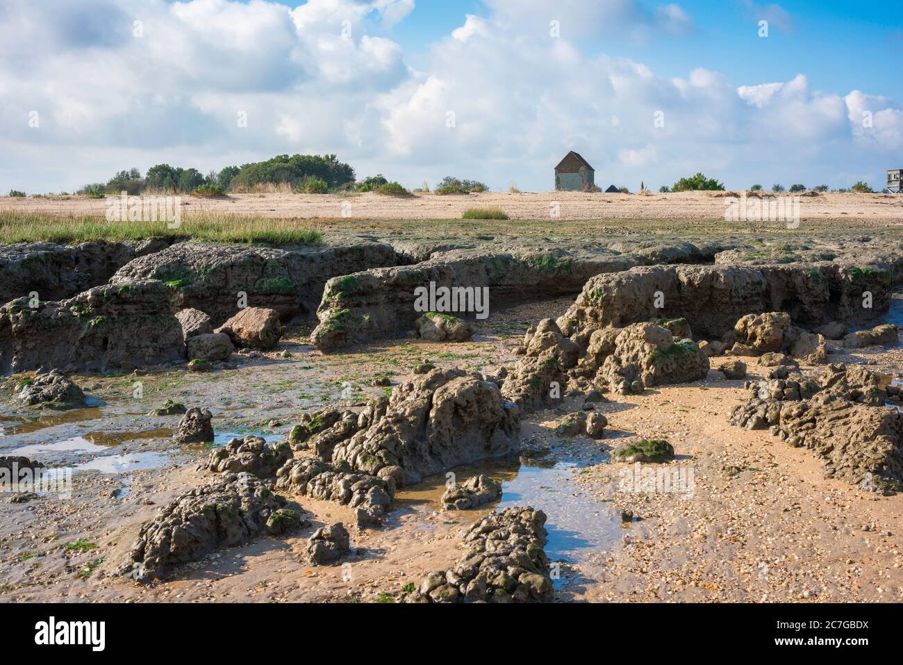 Côte d'Essex Beach, vue sur le paysage accidenté le long de la plage à Bradwell-on-Sea montrant la chapelle Saint-Pierre du VIIe siècle au loin, Essex UK Banque D'Images