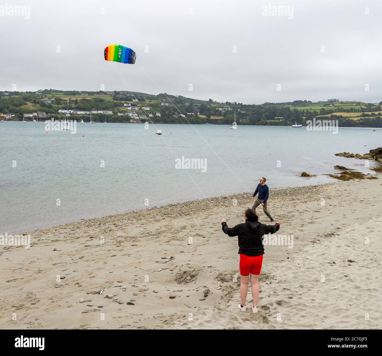 Famille volant un cerf-volant sur la plage, Union Hall, West Cork, Irlande Banque D'Images