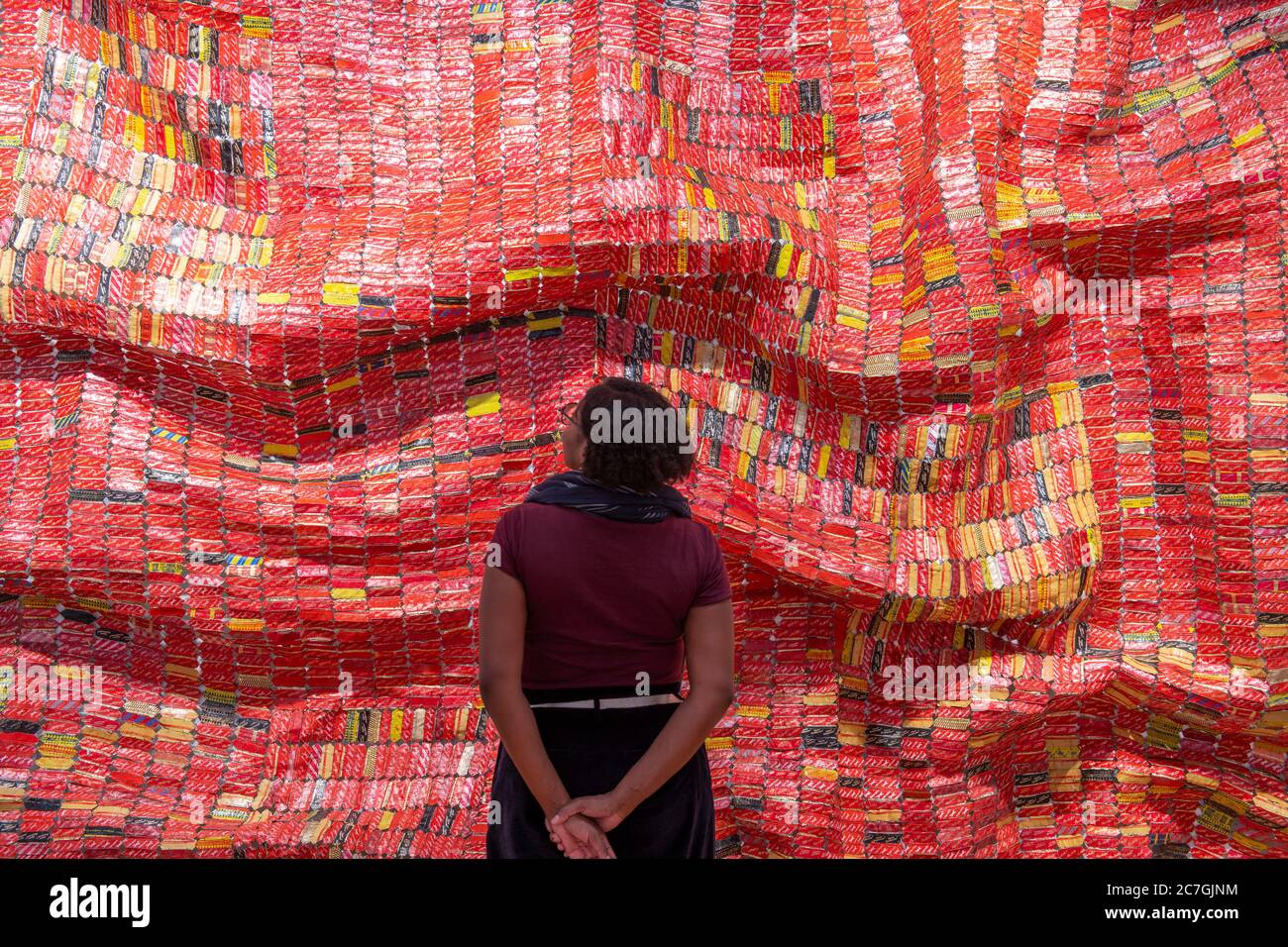 Londres, Royaume-Uni. 17 juillet 2020. Focus sur l'exposition El Anatsui à la Galerie d'octobre se déroule du 15 juillet au 8 août 2020 et présente des œuvres métalliques et une sélection de tirages créés en association avec le Factum Arte, Madrid. El Anatsui est aujourd'hui mieux connu pour ses travaux composés de plusieurs milliers de bottle-tops en aluminium. Le directeur de la galerie Saara étudie l'installation AG + BA, 2014, un travail en métal en deux parties. Crédit: Malcolm Park/Alay Live News. Banque D'Images