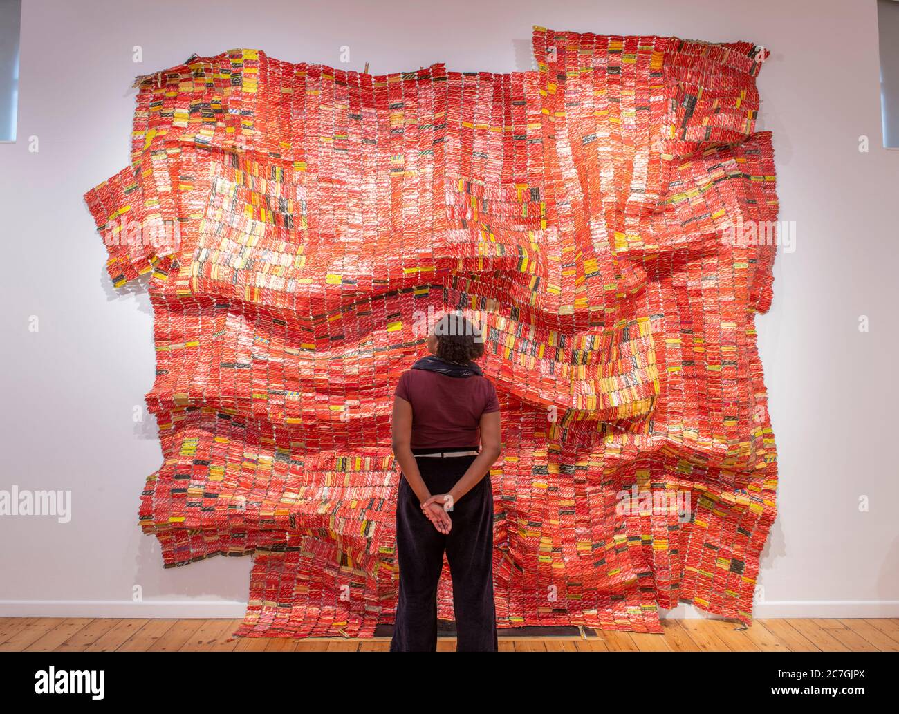 Londres, Royaume-Uni. 17 juillet 2020. Focus sur l'exposition El Anatsui à la Galerie d'octobre se déroule du 15 juillet au 8 août 2020 et présente des œuvres métalliques et une sélection de tirages créés en association avec le Factum Arte, Madrid. El Anatsui est aujourd'hui mieux connu pour ses travaux composés de plusieurs milliers de bottle-tops en aluminium. Le directeur de la galerie Saara étudie l'installation AG + BA, 2014, un travail en métal en deux parties. Crédit: Malcolm Park/Alay Live News. Banque D'Images