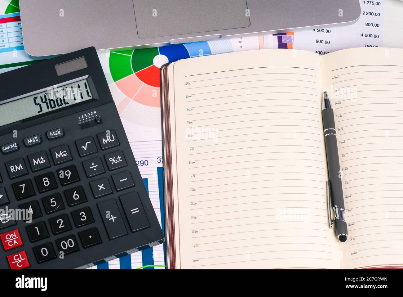 Calculatrice et une page vide du Bloc-notes sur le bureau avec des documents financiers. Stylet, calculatrice et ordinateur portable. Vue de dessus avec une copie de l'espace de saisie de texte Banque D'Images