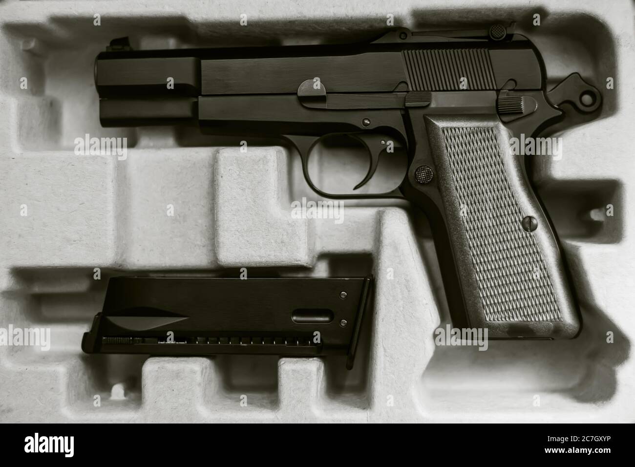 Image en noir et blanc du pistolet acheté et de son magazine dans une boîte  en carton. Achat d'armes. Danger Photo Stock - Alamy