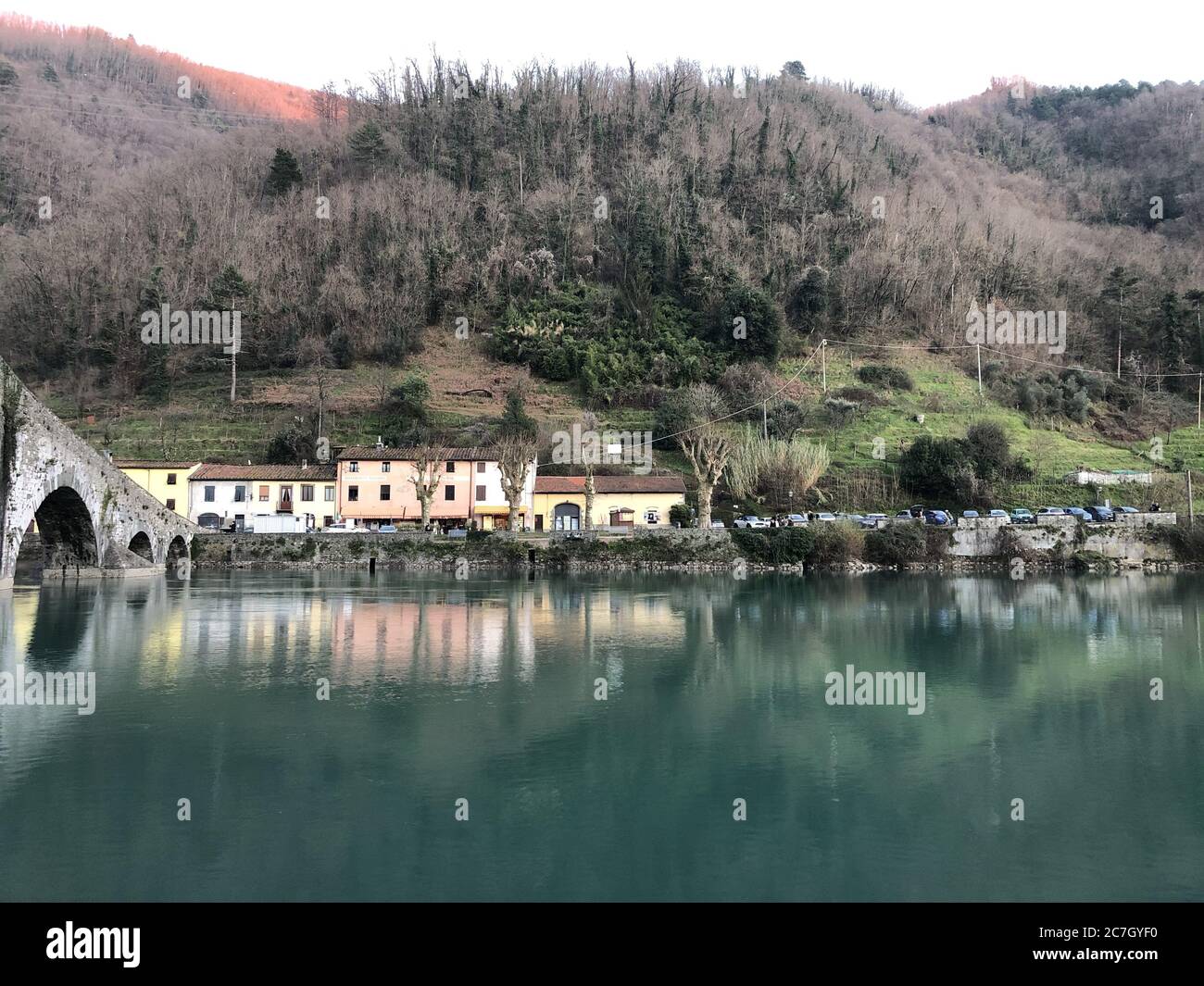 Pont de diable entouré de collines couvertes de forêts et de maisons Réflexion sur l'eau en Italie Banque D'Images