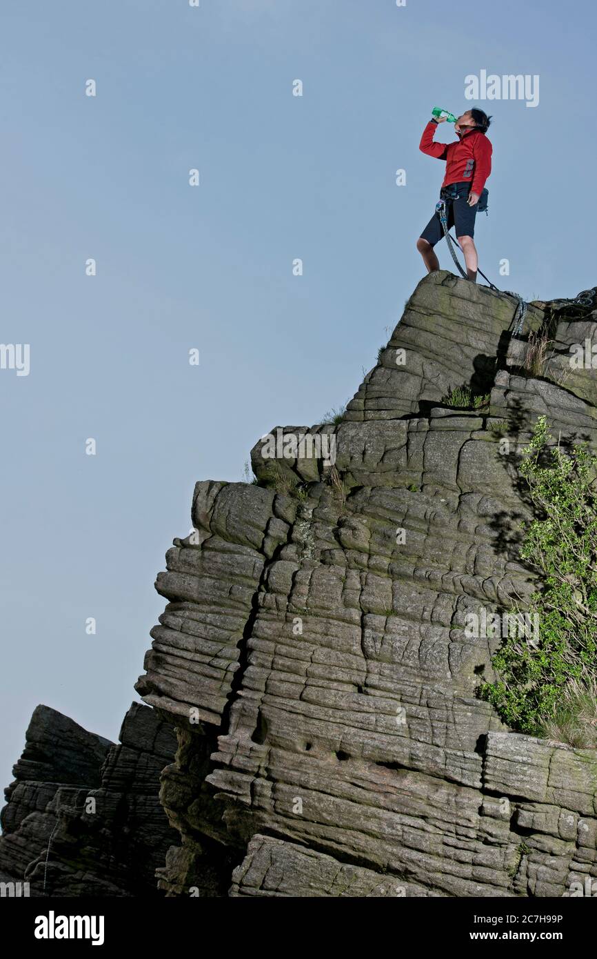 Femme debout au-dessus des rochers de Windcollecde en Grande-Bretagne District de Peak Banque D'Images