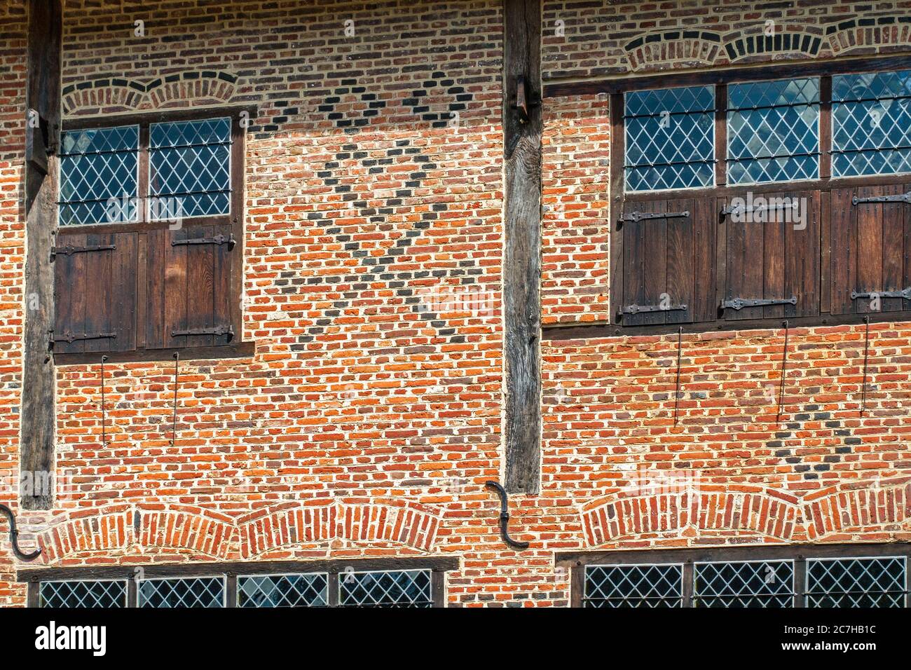 Symboles du maçon flamand en briques sur la façade de la maison en briques du XVIe siècle montrant des checks, des coeurs et des croix de Saint-André, Flandre, Belgique Banque D'Images