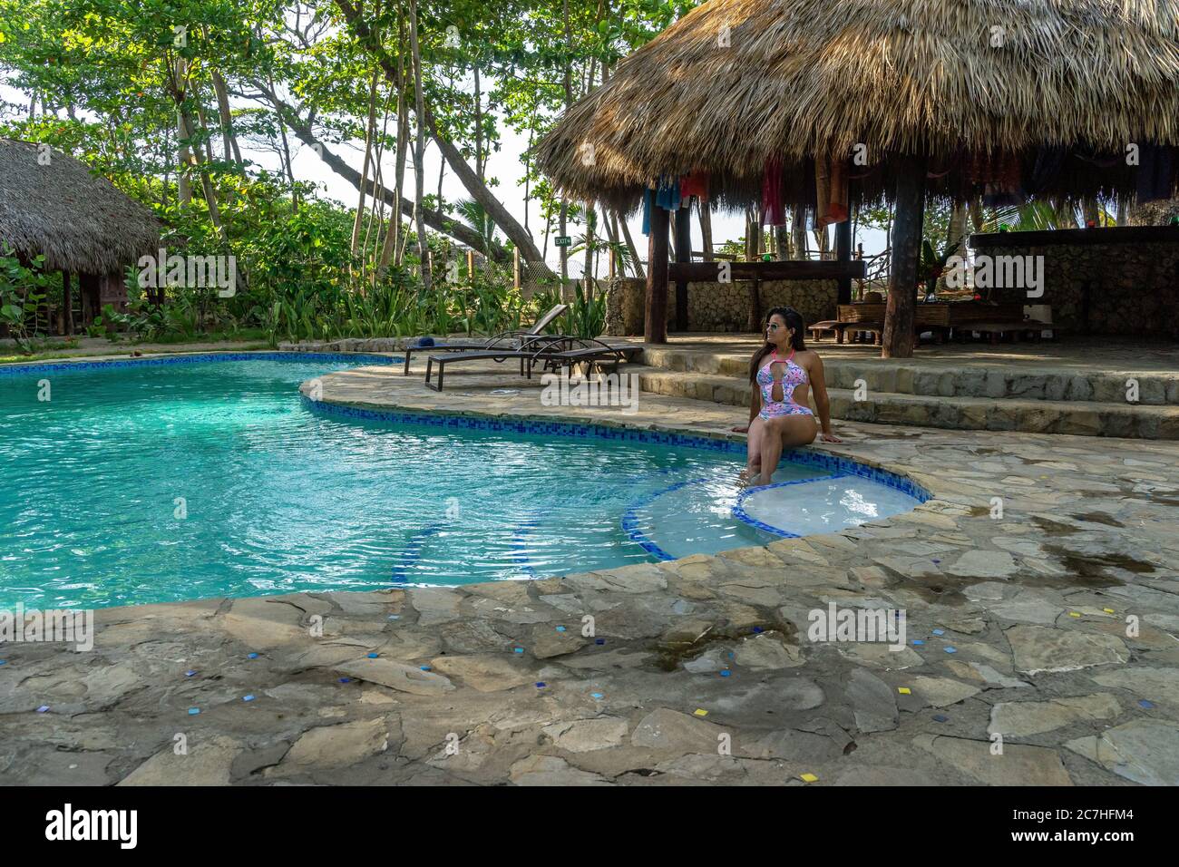 Amérique, Caraïbes, grandes Antilles, République dominicaine, Cabarete, femme assise au bord de la piscine au Natura Cabana Boutique Hotel & Spa Banque D'Images