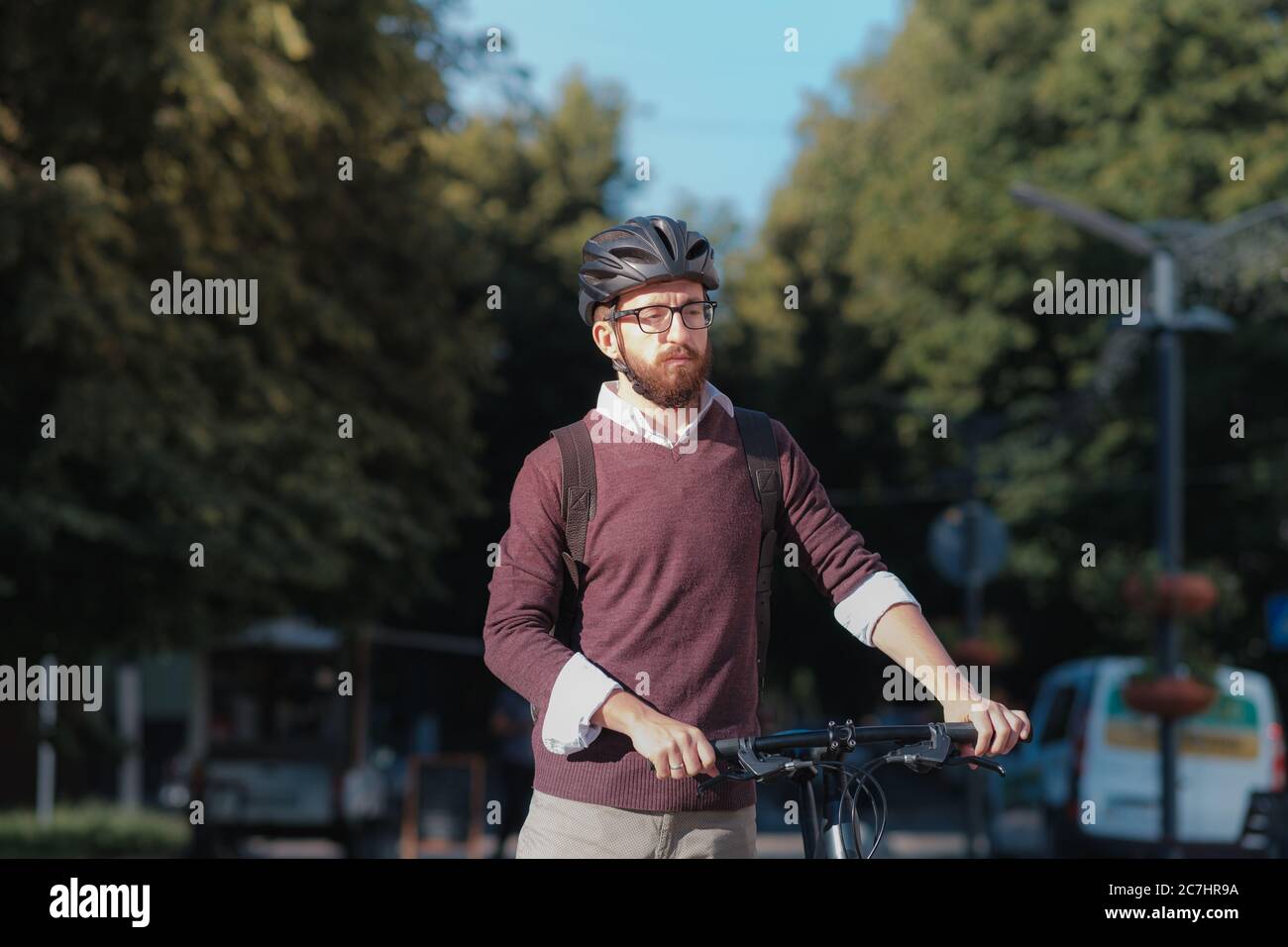 Portrait d'un homme de banlieue portant un casque de vélo dans une ville. Vélo en toute sécurité en ville, trajets à vélo, image active du mode de vie urbain Banque D'Images