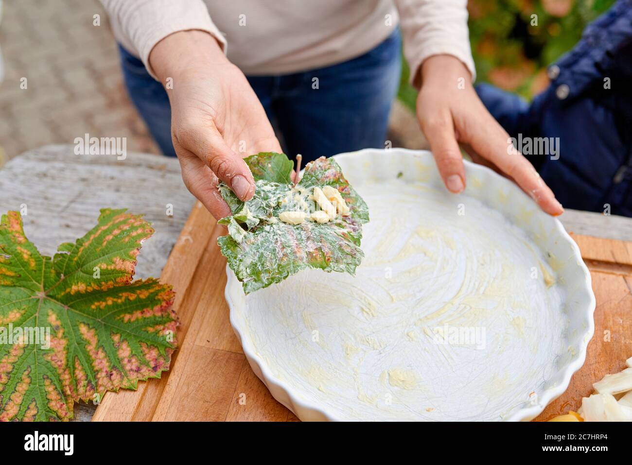 Préparez un gratin de pommes de terre, d'artichauts de citrouille et de Jérusalem, puis graissez la quiche avec du beurre et de l'ail dans la feuille de vigne Banque D'Images