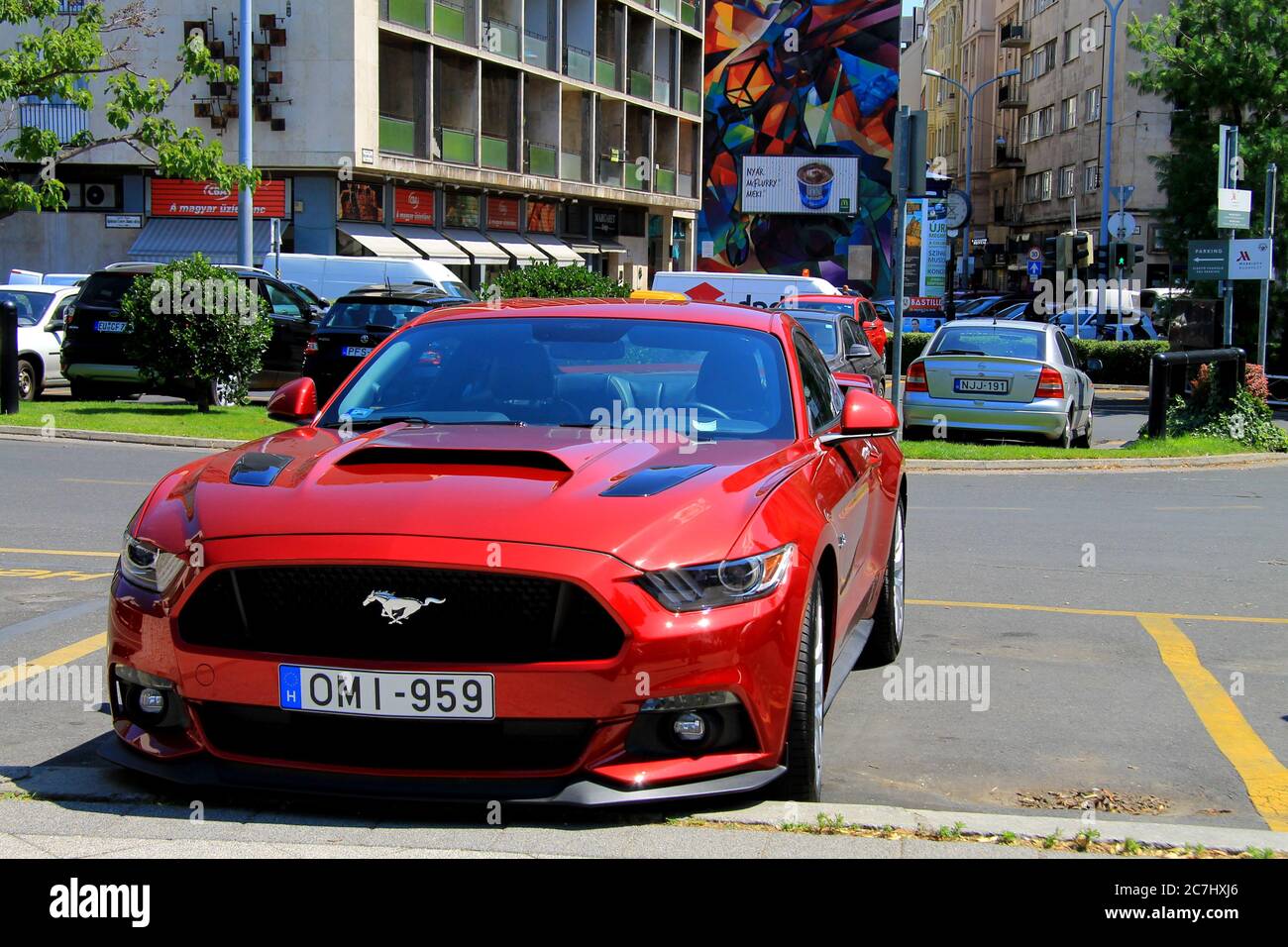 Voiture de sport américaine rouge Ford Mustang avec l'emblème cheval sur le capot est debout sur une rue dans la ville hongroise. Budapest, Hongrie, Europe. Banque D'Images