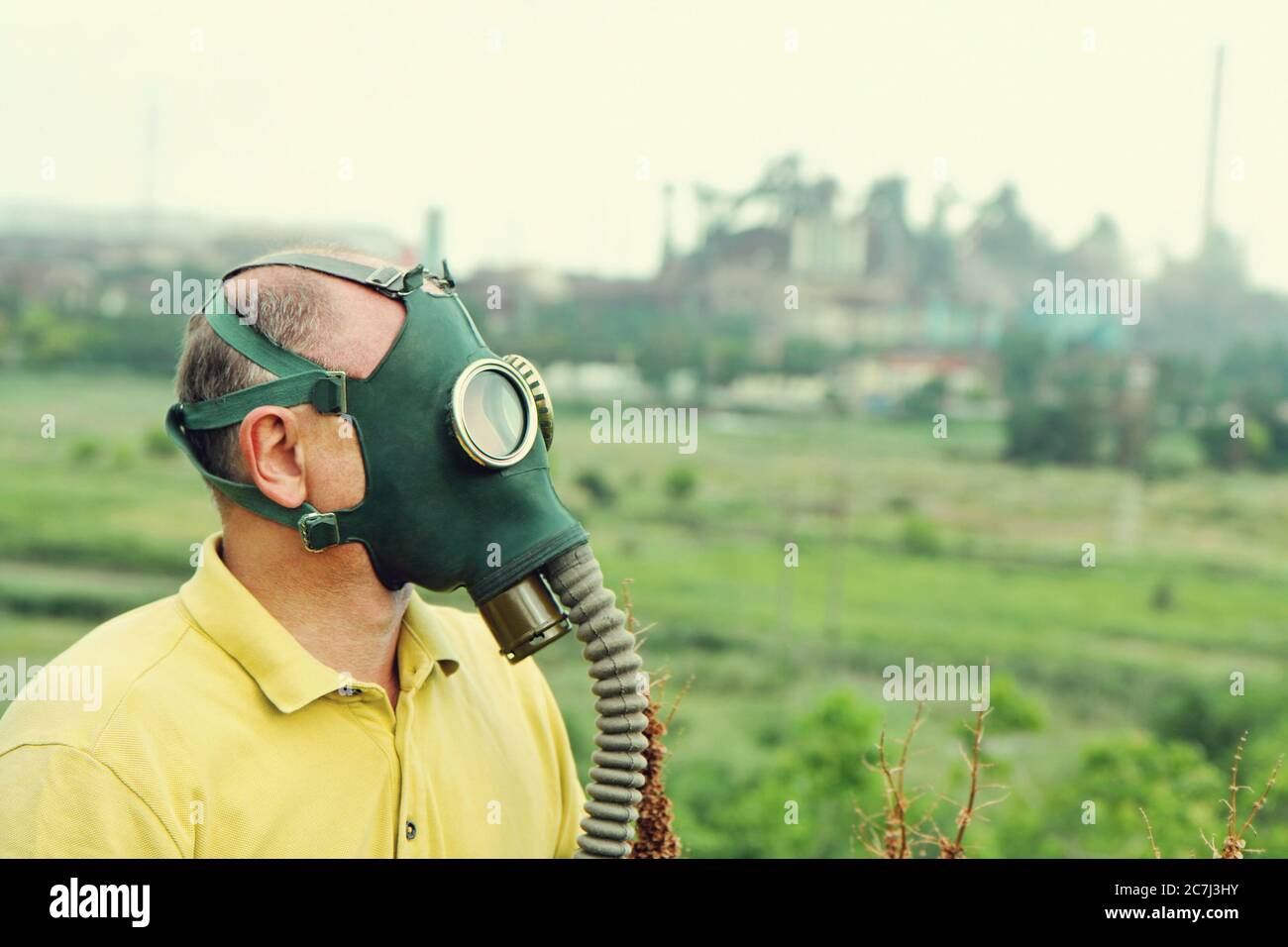 Personne portant un masque à gaz sur un fond industriel. Image de style rétro. Banque D'Images
