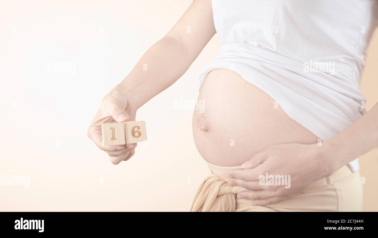 Jeune femme enceinte avec numéro de semaine de grossesse à côté de son ventre. Photos de la croissance du ventre à 17 semaines de grossesse. Alimentation saine pendant la grossesse Banque D'Images