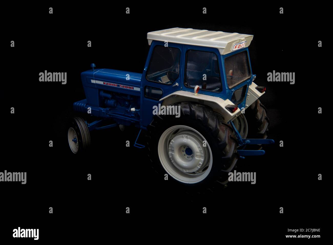 Modèle réduit en métal moulé d'un tracteur classique Ford 5000 sur fond noir Banque D'Images