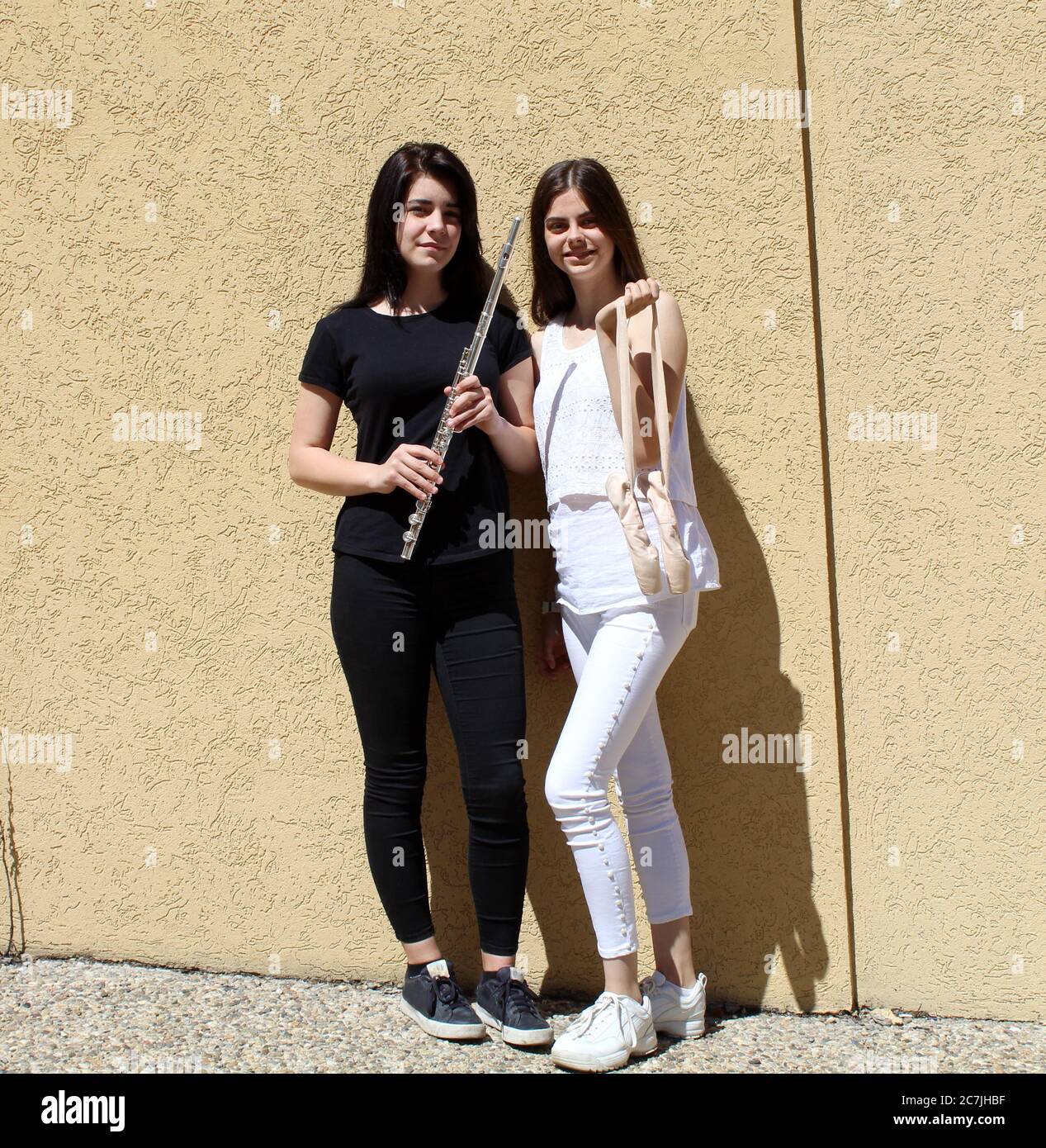 Deux filles vêtues de vêtements noirs et blancs avec flûte et chaussures de danse Banque D'Images