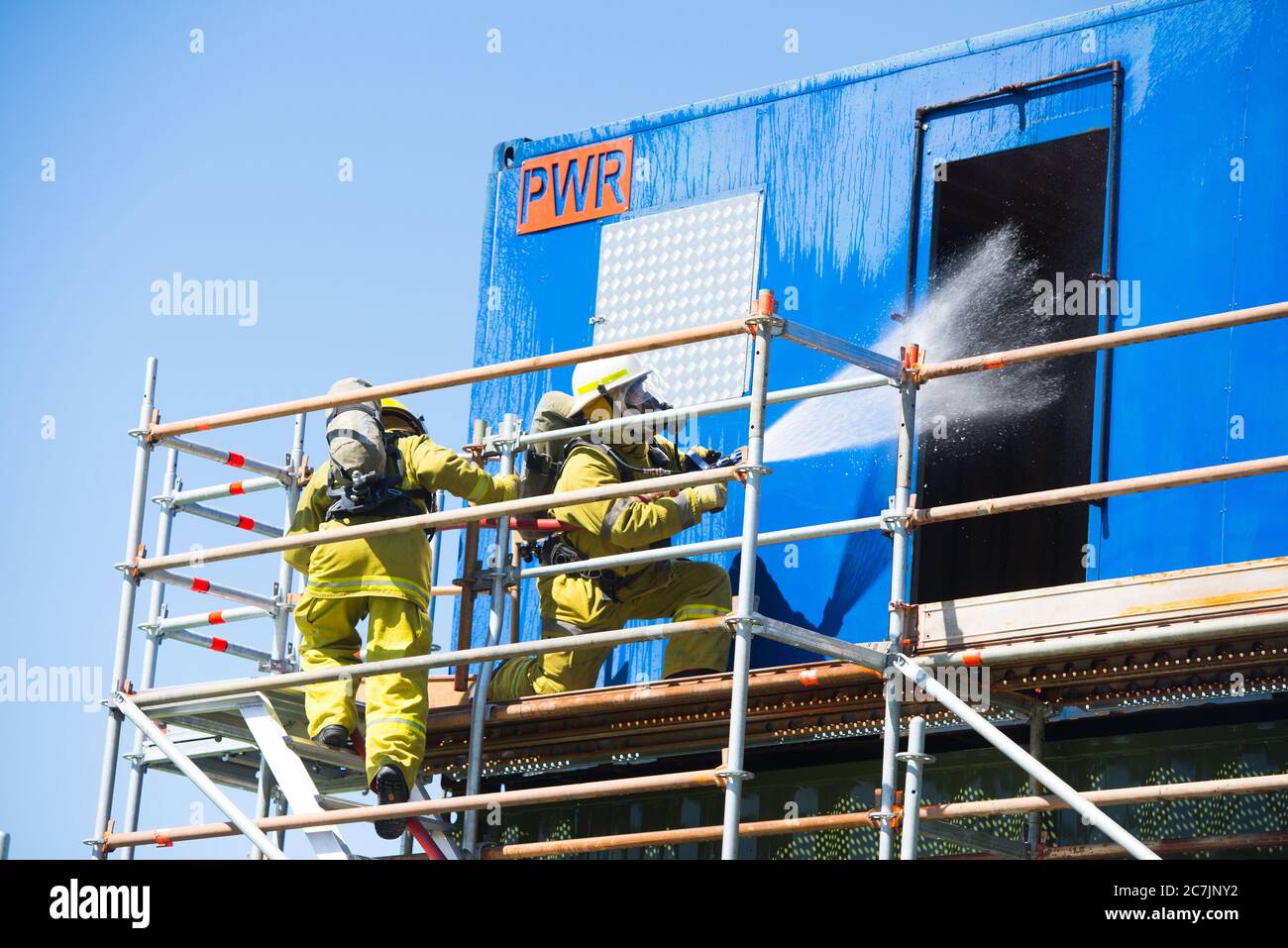 Perth, Australie, 26 novembre 2017 : pompier d'une équipe d'intervention d'urgence avec masque à oxygène et tuyau d'extinction d'incendie avec eau lors de l'exercice d'entraînement Banque D'Images