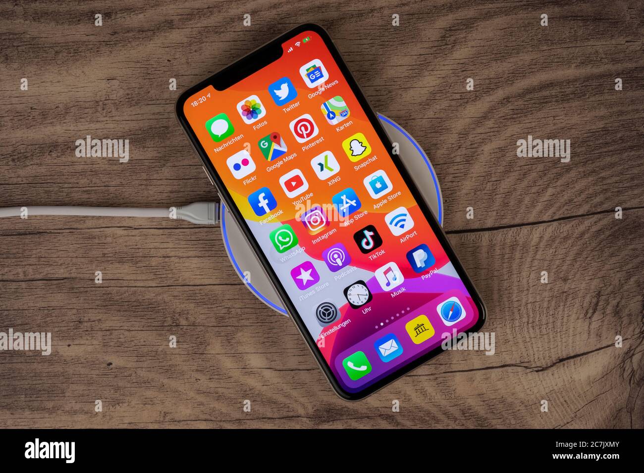 L'iPhone 11 Pro Max d'Apple repose sur un plateau de charge, la charge sans  fil Photo Stock - Alamy