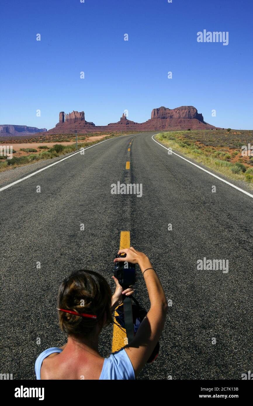 Fille prenant des photos dans la route près de Forrest Gump point, Monument Valley, la vallée est dans la réserve autochtone Navajo, près du monument four Corners et est accessible par l'U,S, route 163, le nom Navajo pour la vallée est TSE BII 'Ndzisgaii (« Vallée des rochers »), Banque D'Images