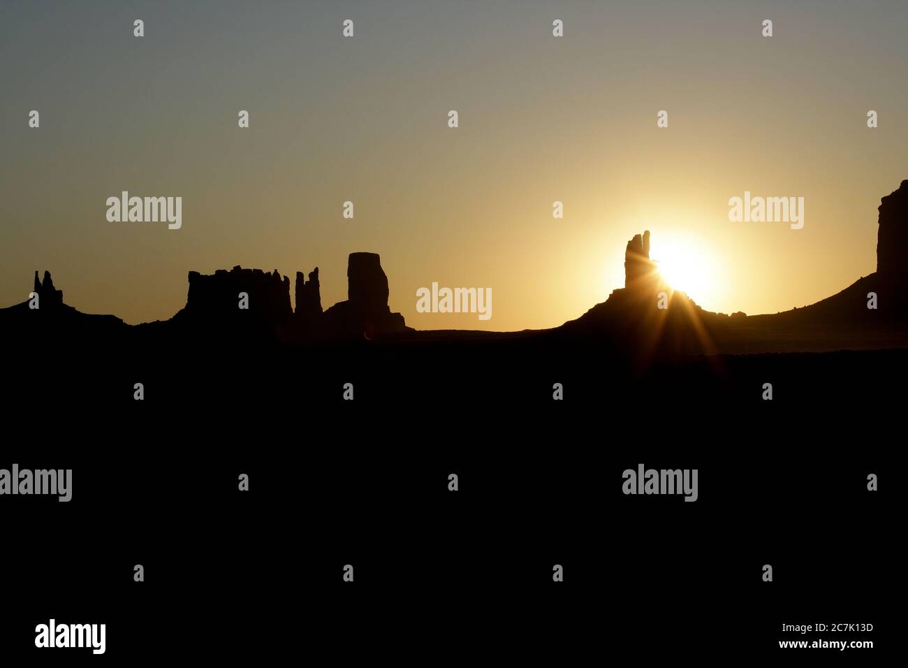 Les célèbres Mittens sont silhouettés au lever du soleil dans Monument Valley, Arizona, la vallée est située dans la réserve autochtone Navajo, près du monument four Corners et est accessible par la route 163, le nom Navajo pour la vallée est TSE BII 'Ndzisgaii (« Vallée des rochers »), Banque D'Images