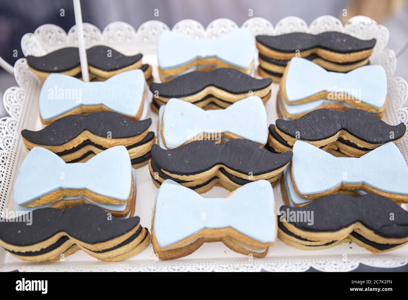 Gros plan de biscuits avec des décorations de moustache et de noeud papillon  sur un bac sous les voyants Photo Stock - Alamy
