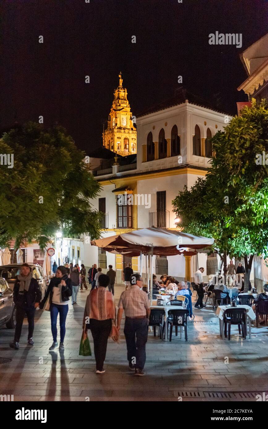 La Torre Campanario illuminée de Córdoba s'élève au-dessus des dîneurs et des promenades du soir sur la Plaza Agrapación de Cofradias Banque D'Images