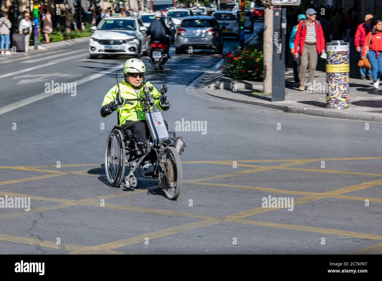 Un homme navigue sur une route de Grenade sur son vélo électrique Rodem Stricker Handbike. Banque D'Images