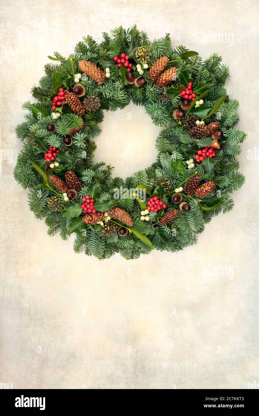 Couronne de Noël en vert naturel avec sapin d'épicéa, houx, cônes de pin et GUI sur papier parchemin ancien. Symbole traditionnel. Banque D'Images Couronne de Noël en vert naturel avec sapin d'épicéa, houx, cônes de pin et GUI sur papier parchemin ancien. Symbole traditionnel. Banque D'Images