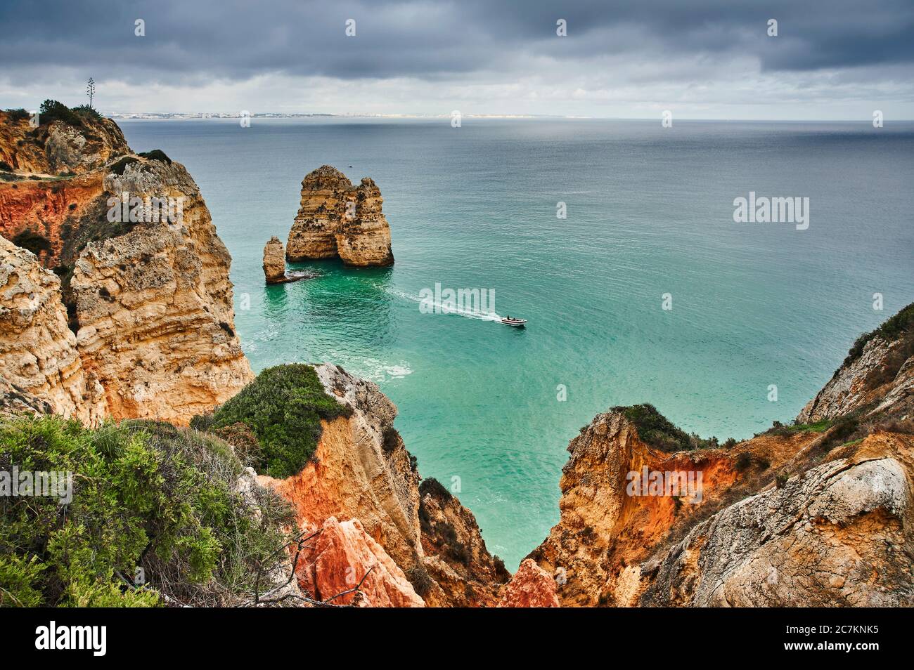 Europe, Portugal, Algarve, Litoral, Barlavento, Felsalgarve, Faro District, Lagos, la côte de Ponta da Piedade, récif rocheux au large et petit bateau à moteur Banque D'Images