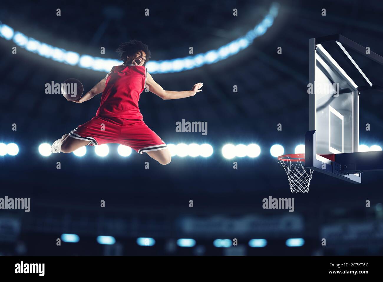 Slam Dunk acrobatique d'un joueur de basket dans le panier dans le stade Banque D'Images