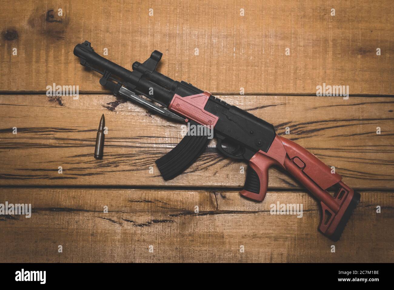 Tir en grand angle d'une arme à feu avec une balle une surface en bois Banque D'Images