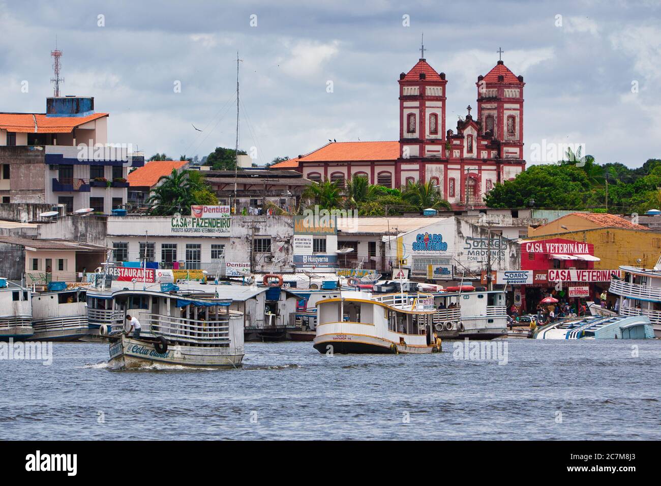 Activités de bateaux sur le front de mer de Santarem avec une église au-delà, sur la rivière Amazone, État de Para, Brésil, Banque D'Images