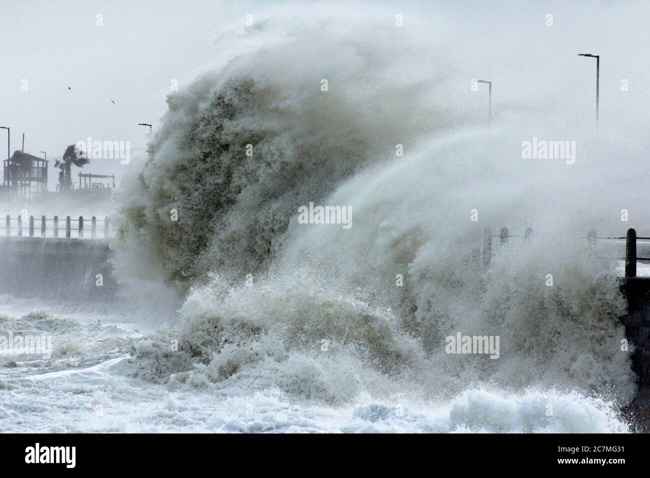 Des vagues de tempête massives battent le sentier côtier du Cap lors d'une intense tempête hivernale. Banque D'Images