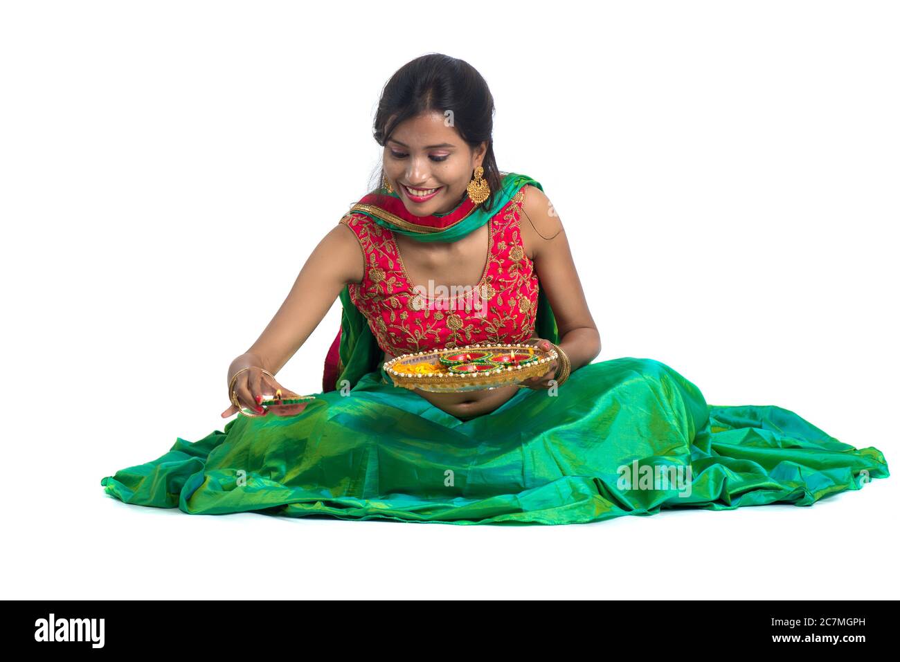 Portrait d'une fille traditionnelle indienne tenant Diya et faisant Rangoli. Fille célébrant Diwali ou Deepavali avec la tenue de lampe à huile pendant le festival de l Banque D'Images
