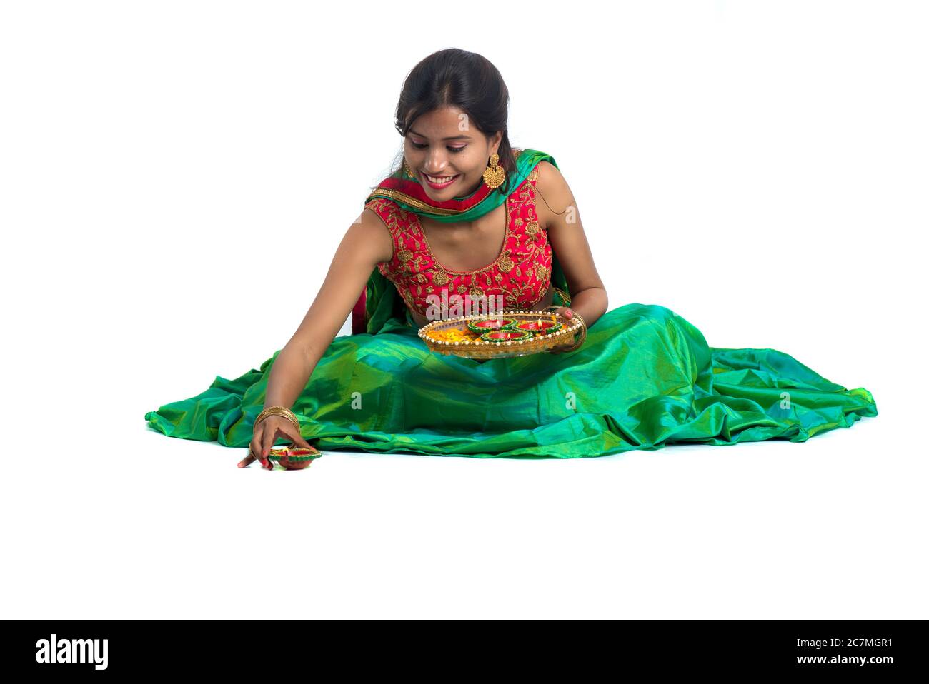 Portrait d'une fille traditionnelle indienne tenant Diya et faisant Rangoli. Fille célébrant Diwali ou Deepavali avec la tenue de lampe à huile pendant le festival de l Banque D'Images