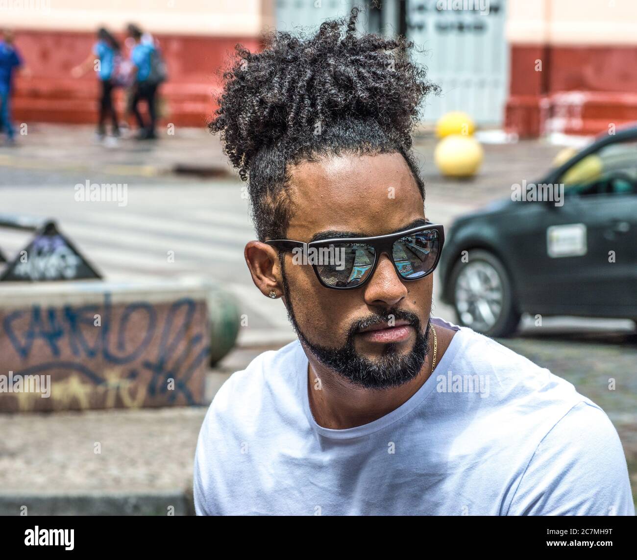 Homme noir aux cheveux bouclés avec lunettes de soleil dans la rue Photo  Stock - Alamy