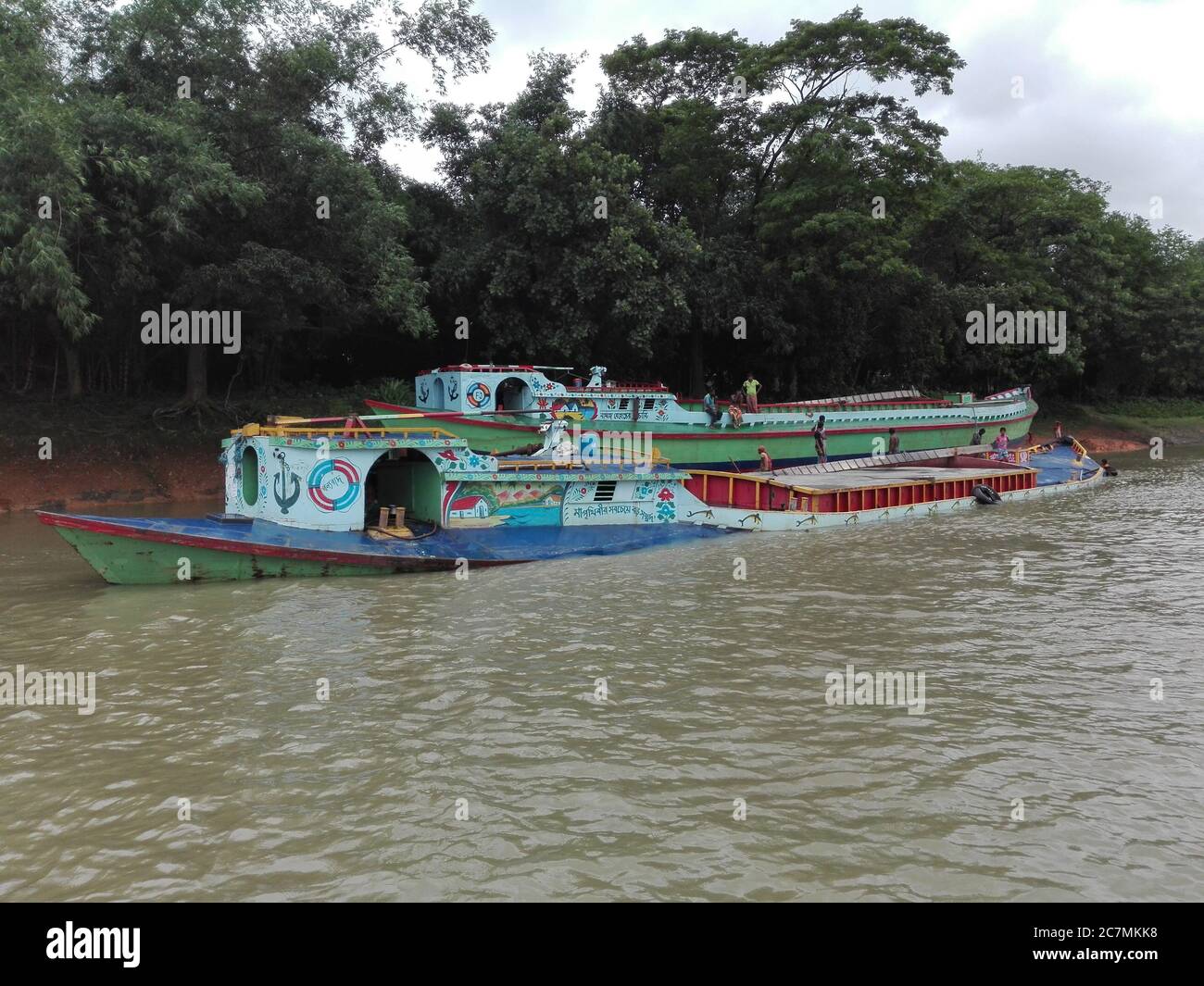 Des bateaux cargo peints gaious transportant du sable sur la rivière Turag à Gazipur, Bangladesh. Banque D'Images