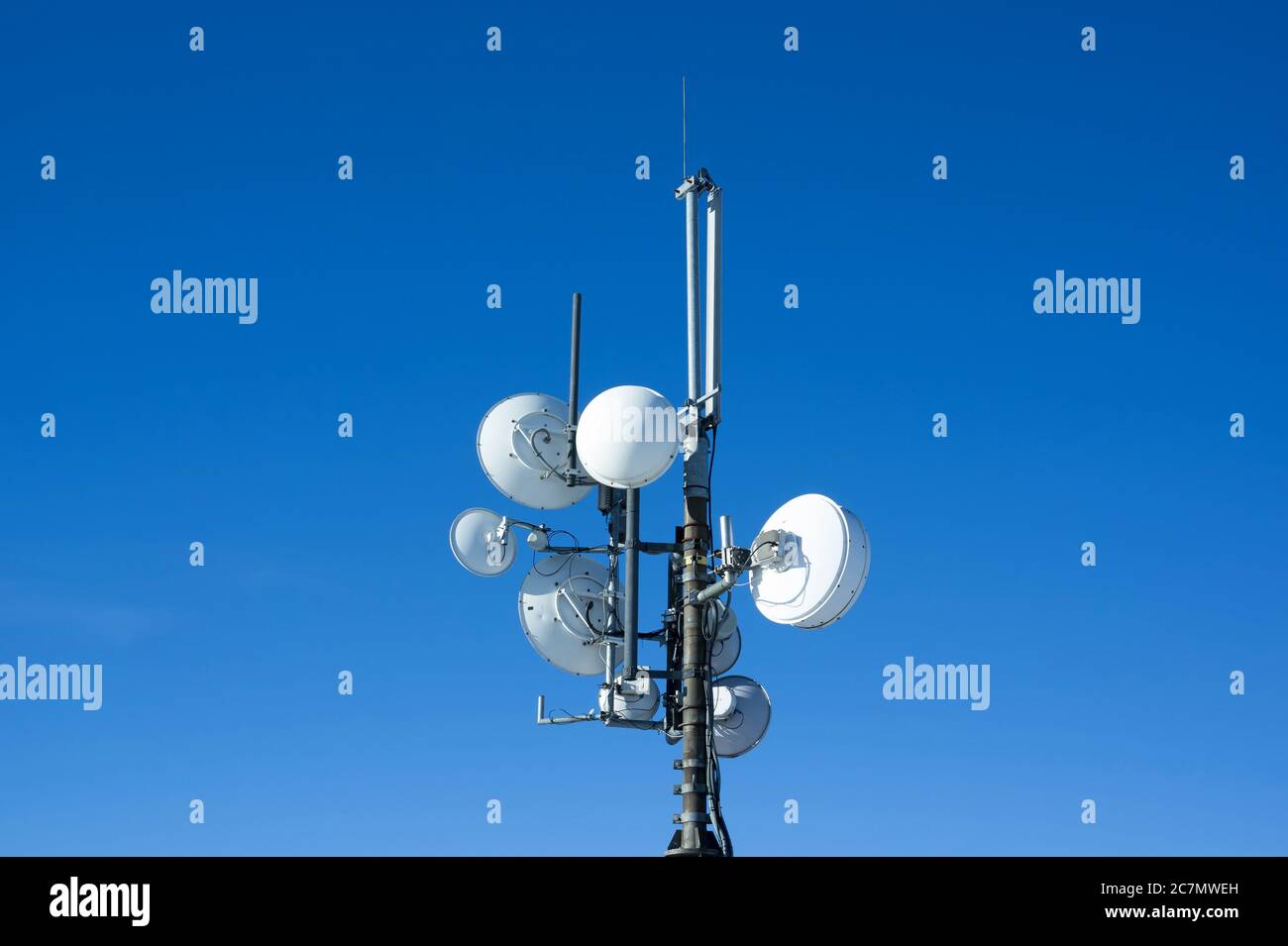 Satellites et antennes - dispositifs de fourniture, de transmission et de distribution de signaux. Bleu clair ciel clair comme arrière-plan et zone de copie Banque D'Images