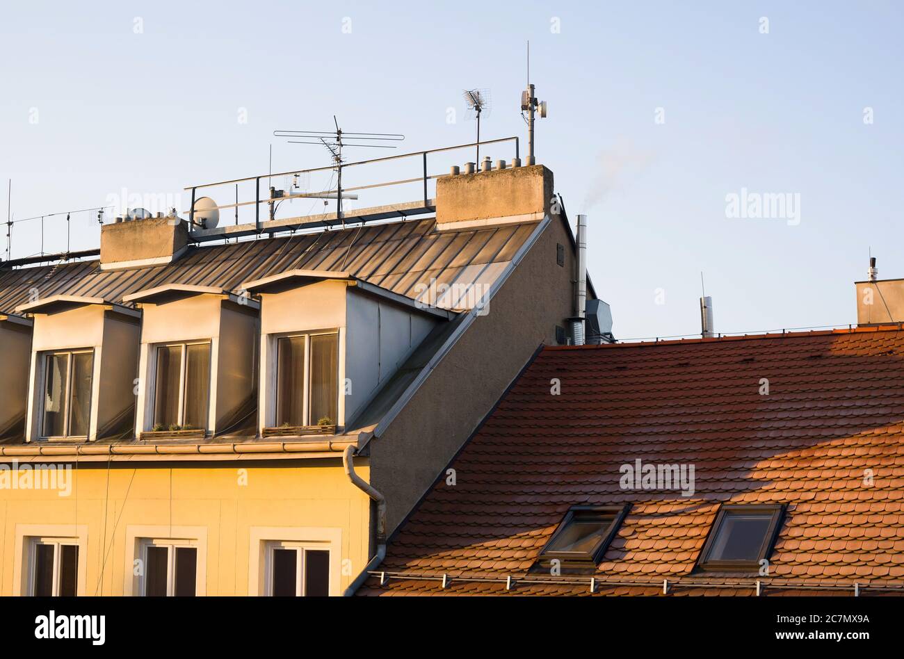 Toit de l'ancien bâtiment. Les tuiles de toiture, le satellite, les antennes et les dortoirs sont sur le toit. Ciel bleu clair et lumière jaune du matin/soir Banque D'Images