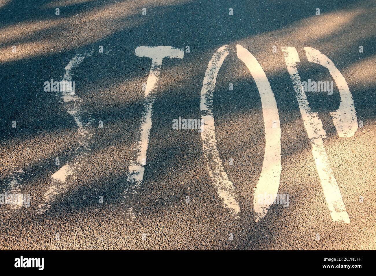 Mot d'arrêt sur l'asphalte. Marquage d'avertissement inscrit sur la chaussée. Les lettres de sécurité routière sont peintes sur la surface de la route. Grunge texte sur le plancher de transport. Conceptua Banque D'Images