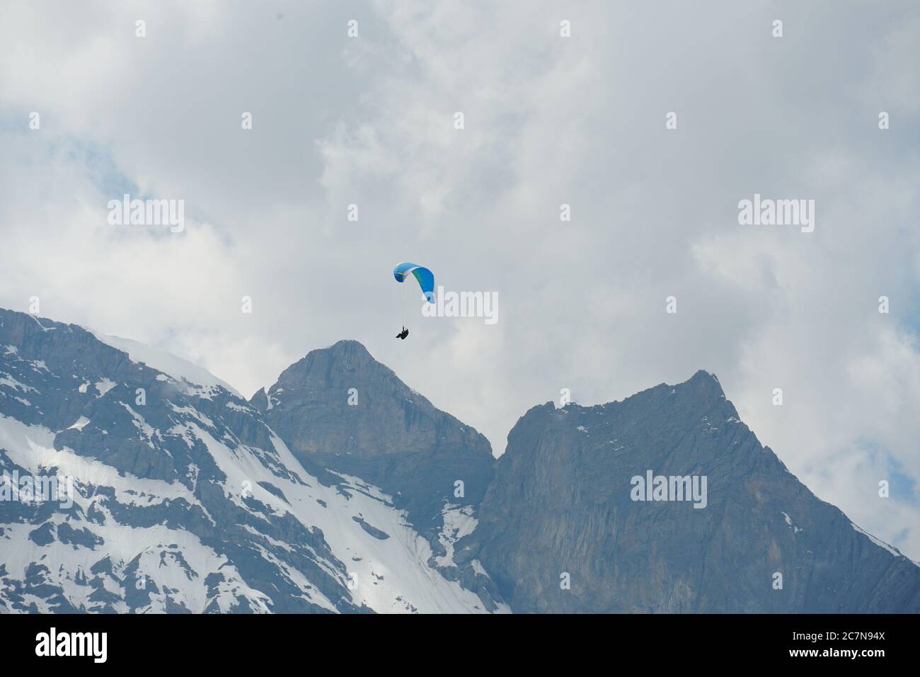 Un parapente qui glisse sur les sommets de la région du canton d'Engelberg Obwalden en Suisse au printemps, lorsque les pentes des Alpes sont enneigées. Banque D'Images