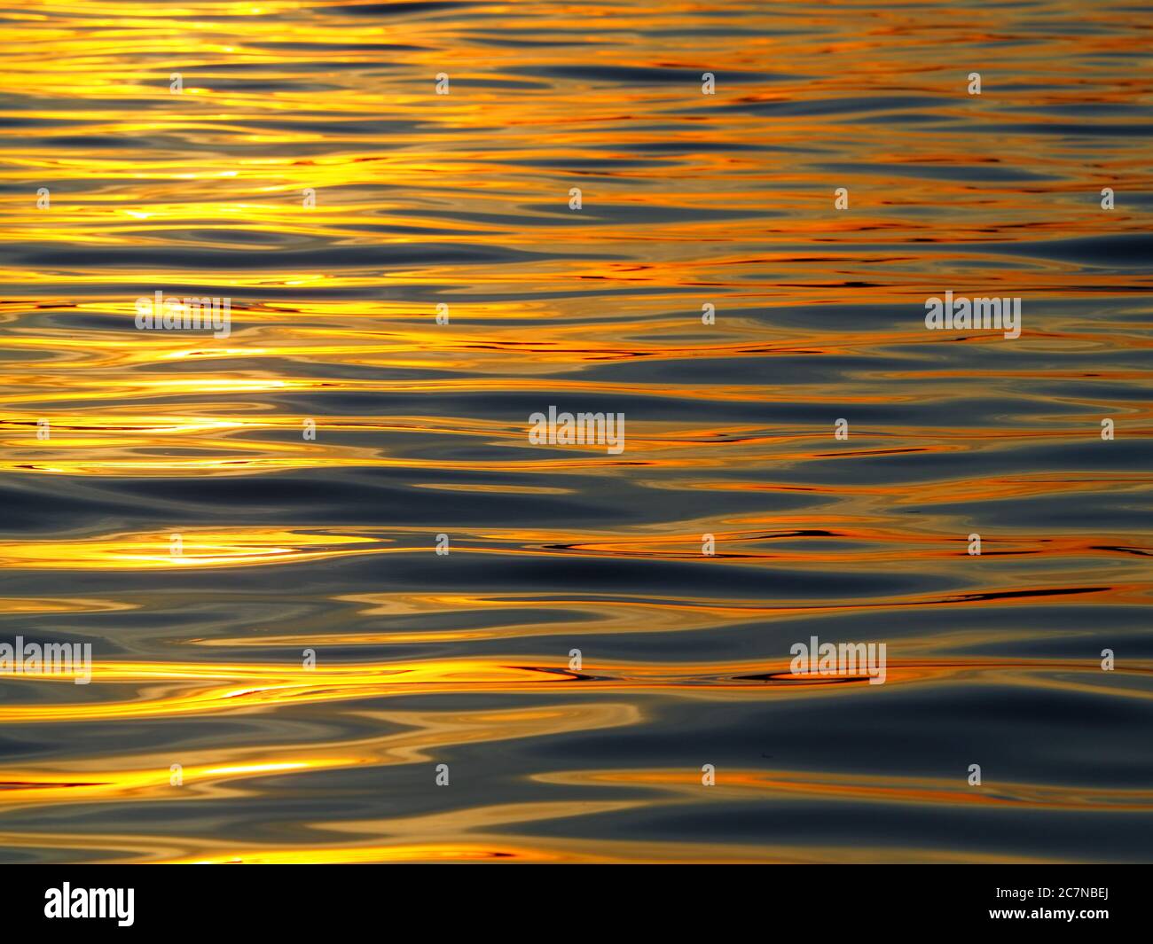 Cliché abstrait de l'eau ondulée à l'orange illuminée Banque D'Images Cliché abstrait de l'eau ondulée à l'orange illuminée Banque D'Images