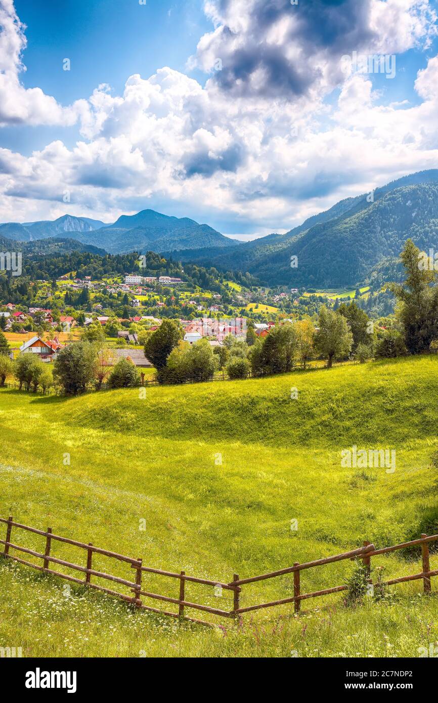 Paysage alpin magnifique avec champs verts et montagnes Piatra CRAiului dans la commune de Dambovicioara. Emplacement : village de Podu Dambovitei, comté d'Arges, D. Banque D'Images