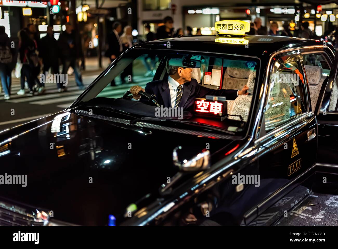 Kyoto, Japon - 9 avril 2019 : rue Gion avec bâtiments éclairés bokeh nuit colorée et taxi noir dans la circulation avec chauffeur à l'intérieur Banque D'Images