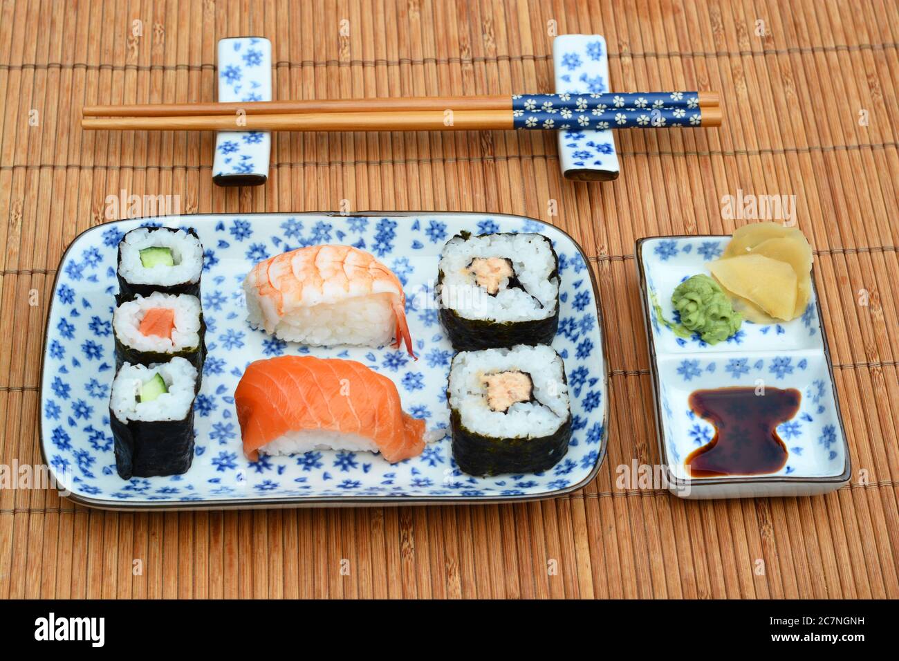 Gros plan de petits pains à sushis, de sauce et de boulettes dans des  assiettes à côté des baguettes sur la couverture de table en bambou Photo  Stock - Alamy